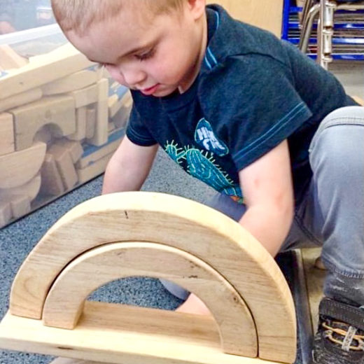 Boy playing with wooden blocks.