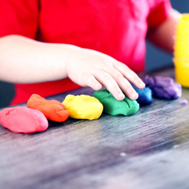 A little boy playing with clay.