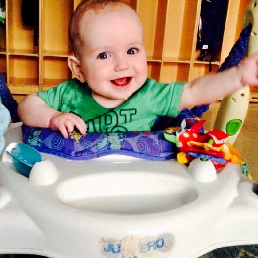 A baby is sitting in a baby walker.