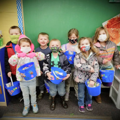 A group fo children standing and wearing masks.