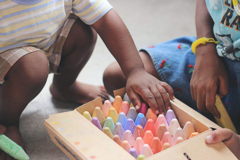 Babies playing with chalk.
