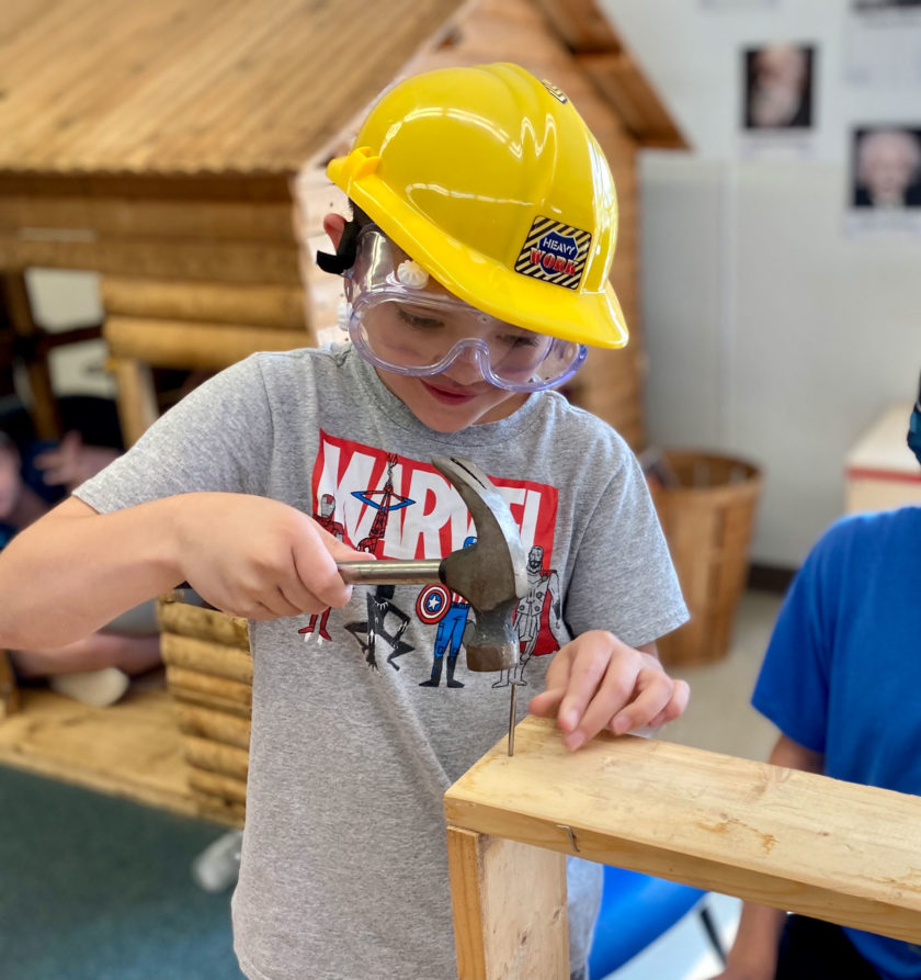 A boy playing with a toy hammer.