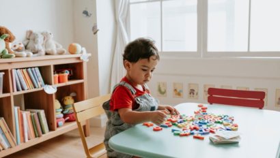 A young child playing with colorful alphabet blocks.