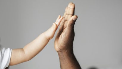 A child holding her hand up to an adult.