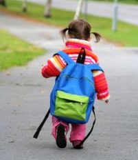 A child walking with a backpack.