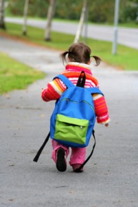 A child walking with a backpack.