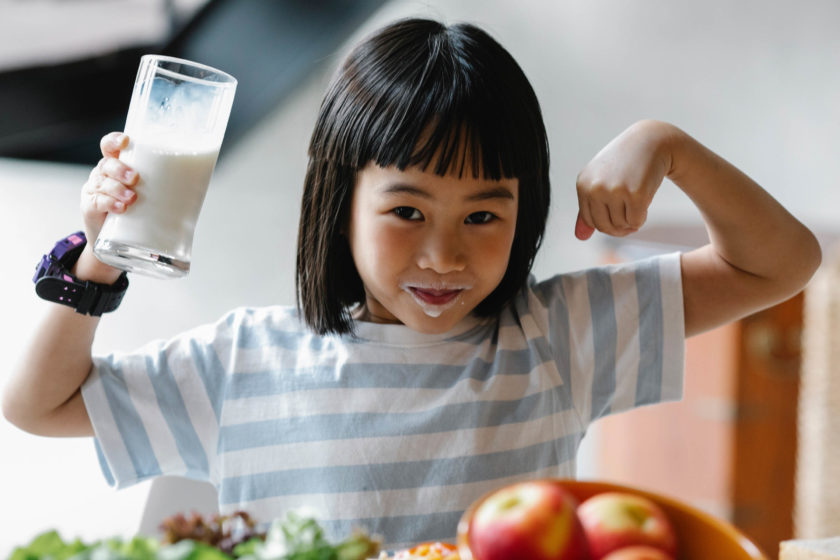 A girl holding a glass of milk.