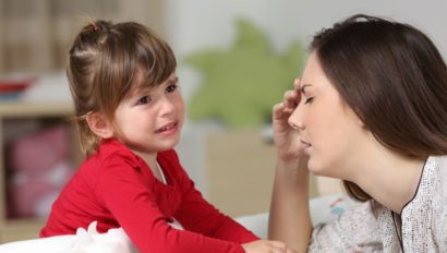 A young woman frustrated with a young girl having a tantrum.