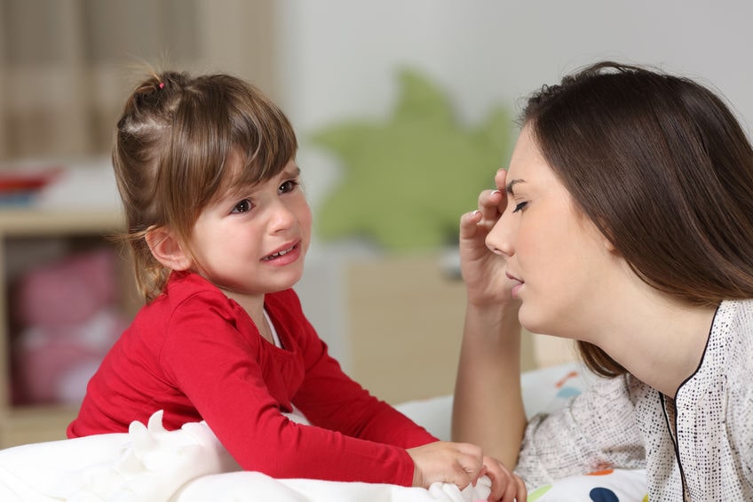 A young woman frustrated with a young girl having a tantrum.