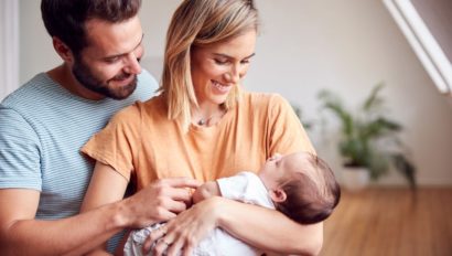 two young parents holding a baby.