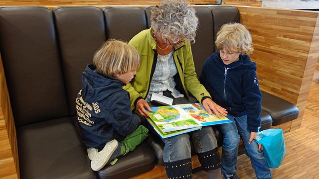 A woman reading a book to a group of children.