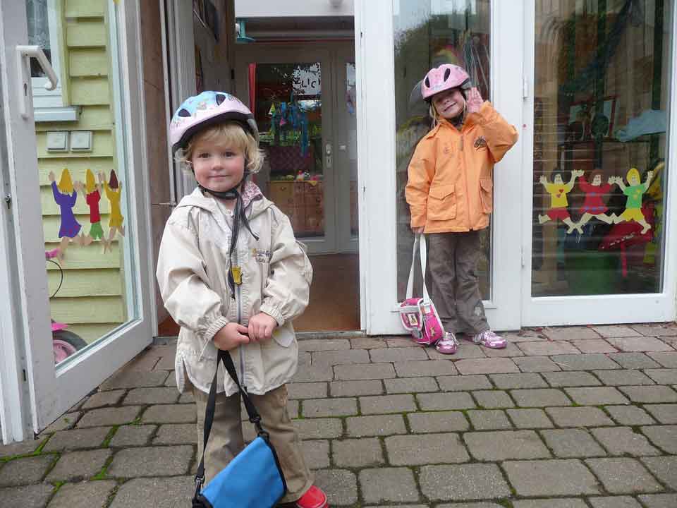 Two children standing in front of a building.