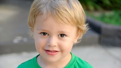 A young boy wearing a green t - shirt.