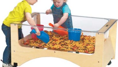 Two children playing with a sand table.