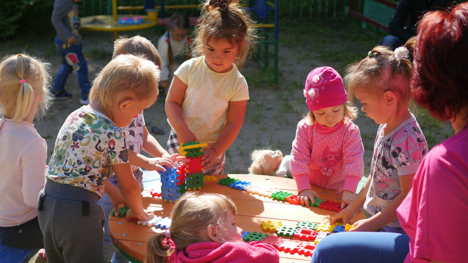 A group of children playing with blocks at a table.