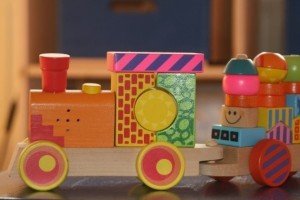 A wooden toy train with colorful balls on it.